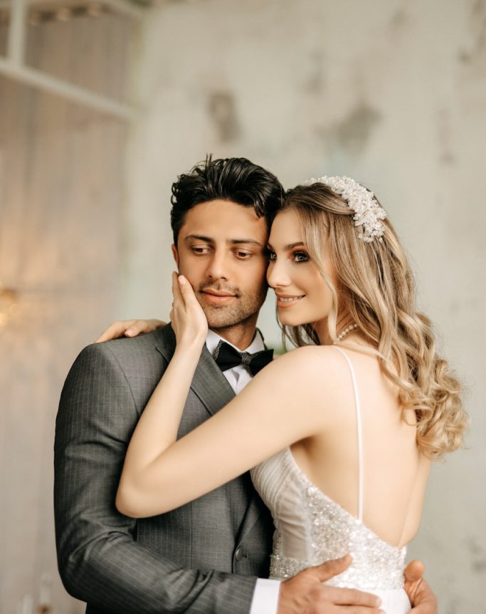Brautpaar in Hochzeitskleidung bei einer innigen Umarmung