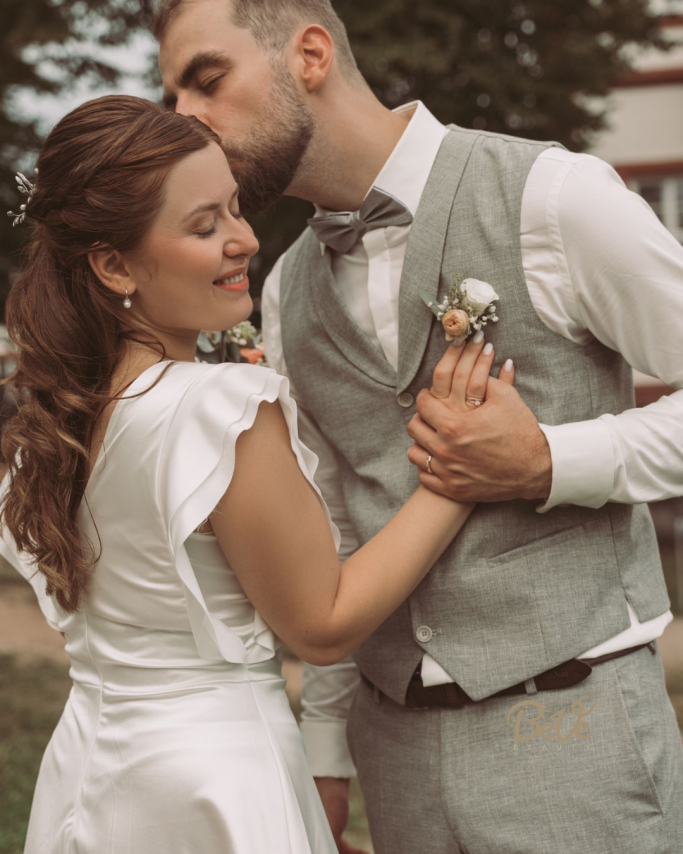 Brautpaar in Hochzeitskleidung bei  Umarmung