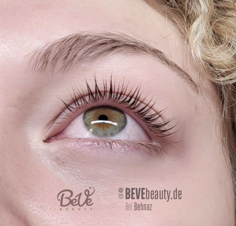 Nahaufnahme eines braunen Auges mit langen Wimpern und hellem Schimmer.